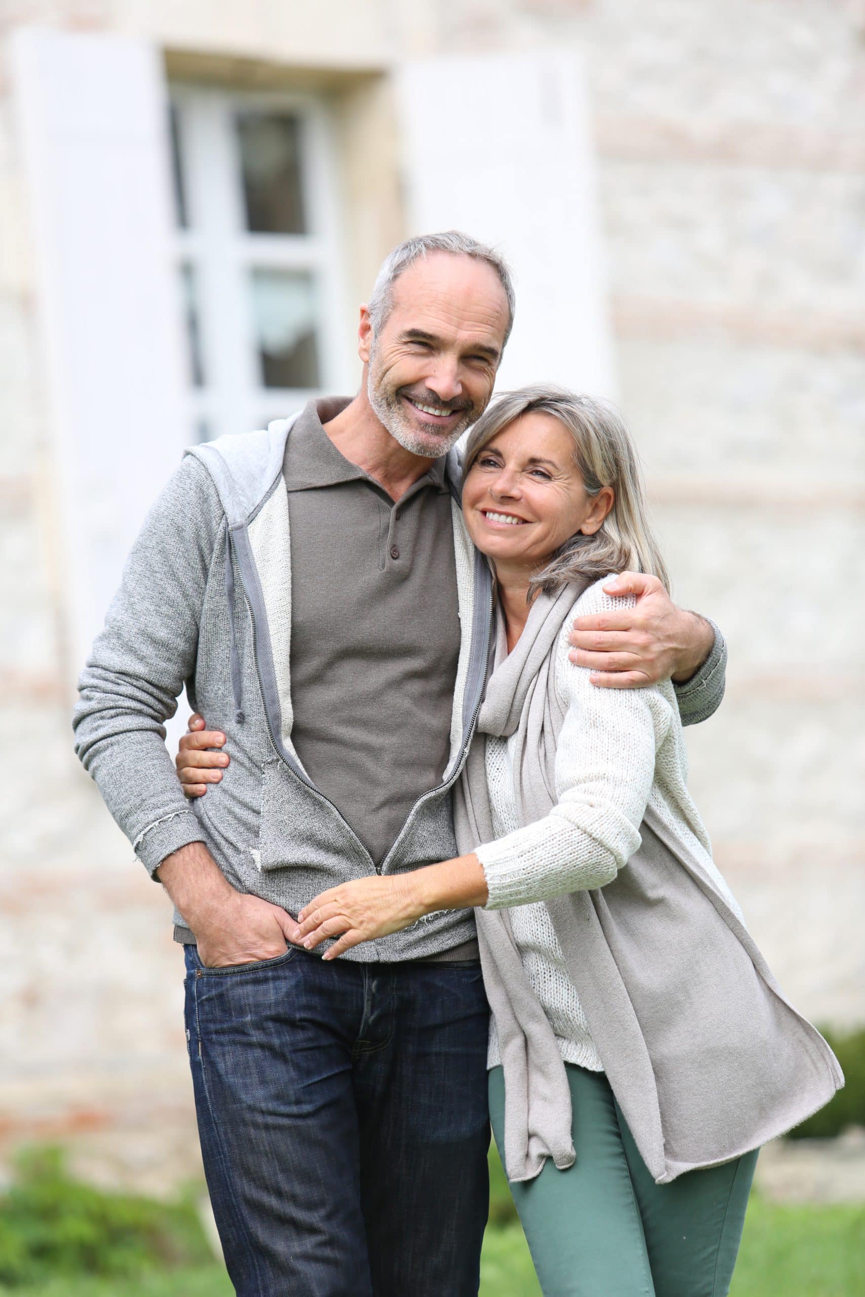 Older patients embracing and smiling with white teeth